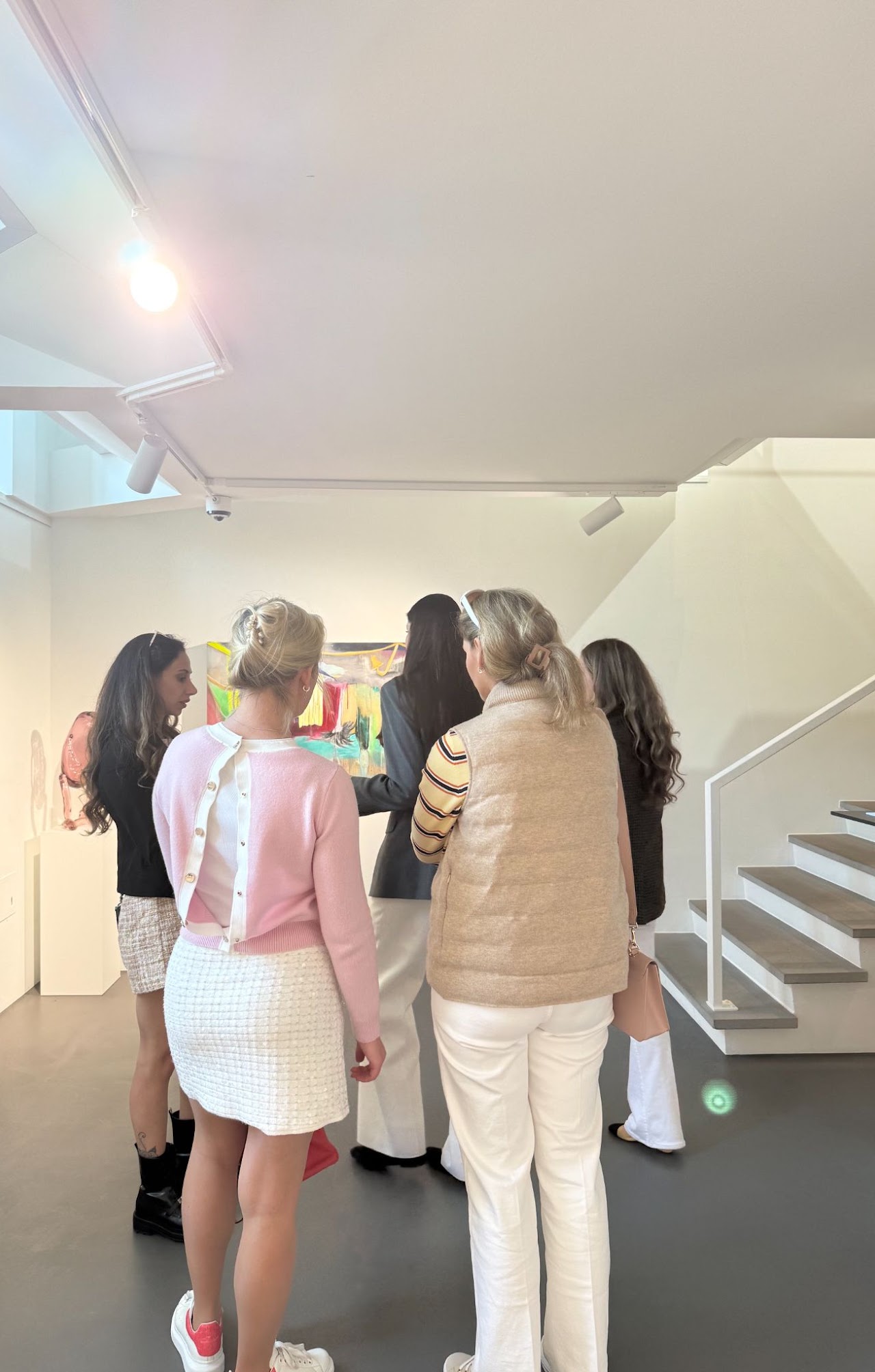 Members admiring colourful abstract paintings during a private gallery vernissage