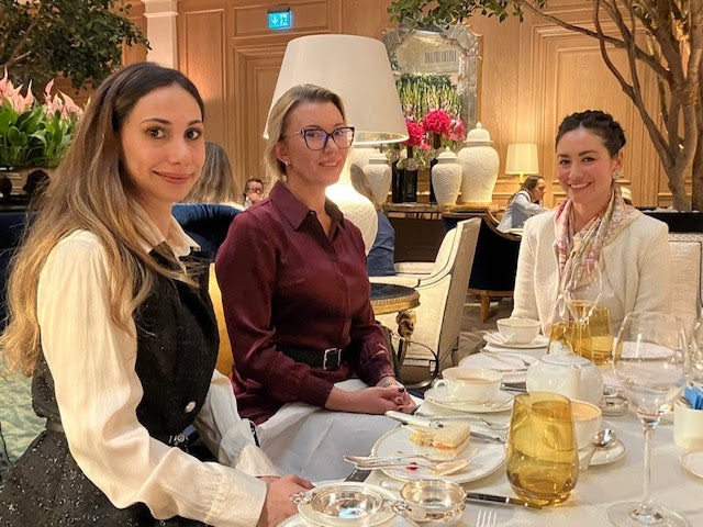 Three members taking afternoon tea in an elegant hotel salon with silver service